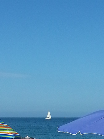 Beach umbrellas and sailboat on the Mediterranean Sea, Parc De La Pau